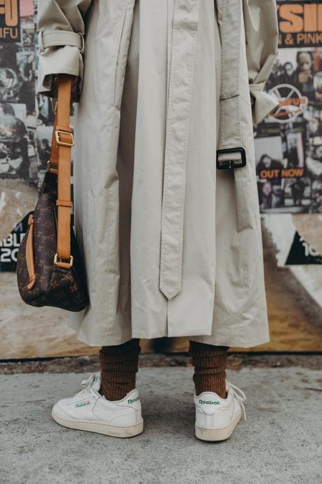 Sara from Collage Vintage wearing a Nili Lotan set in army green paired with a vintage trench coat and Reebok retro sneakers