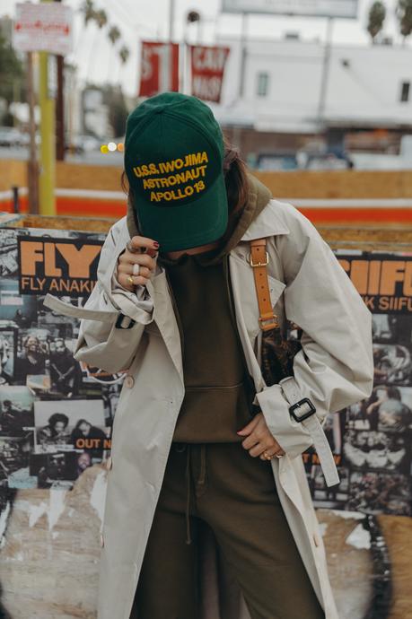 Sara from Collage Vintage wearing a Nili Lotan set in army green paired with a vintage trench coat and Reebok retro sneakers