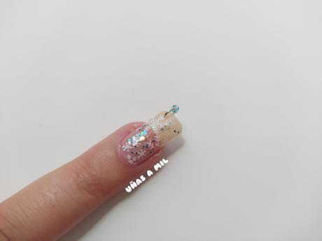 Diseño de uñas con copos de nieve, glitter y piercing