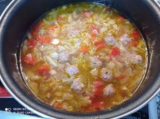 Cociendo la sopa de repollo, verduras y albóndigas