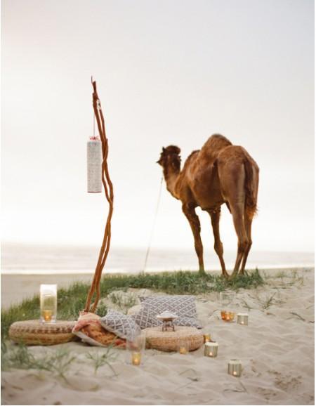 velas puffs de mimbre picnic arena playa farolillos estilismo de exteriores decoración exteriores cojines de diseño atardecer 