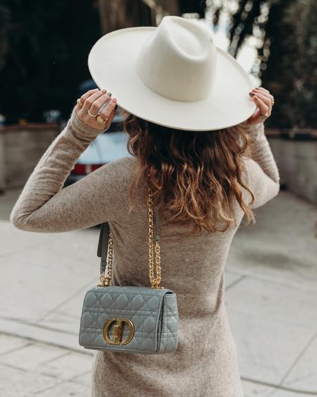 Sara from Collage Vintage wearing a midi knit dress, all star sneakers and cloud blue Caro Dior bag