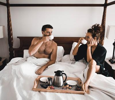 Pareja de novios desayunando en la cama