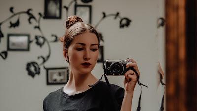 Mujer tomándose una fotografía delante de un espejo