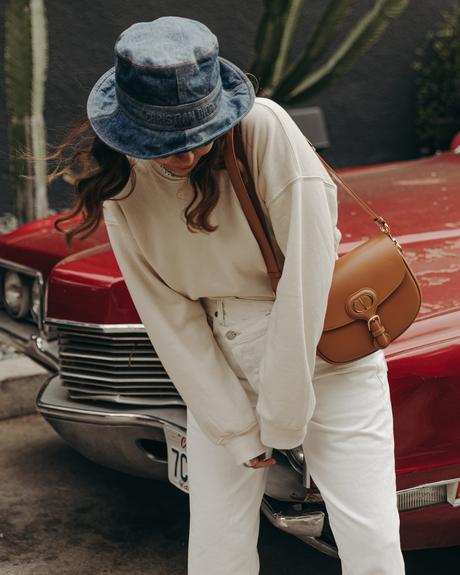 Sara from Collage Vintage wearing Agolde white jeans, Dior denim bucket hat and Converse All-Star