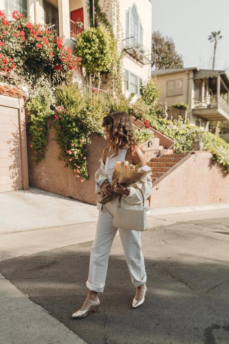 Sara from Collage Vintage wearing Mother jeans, cream raffia Cult Gaia bag and Agolde denim jacket