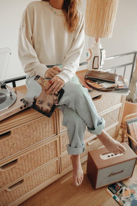 Must-loved denim wearing Agolde jeans and cropped sweatshirt at home