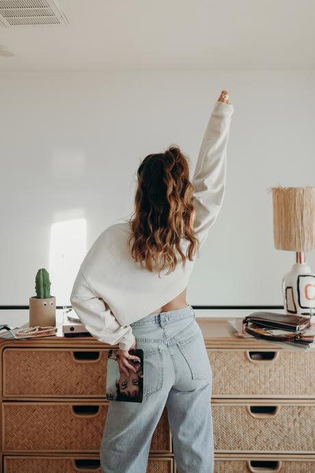 Must-loved denim wearing Agolde jeans and cropped sweatshirt at home