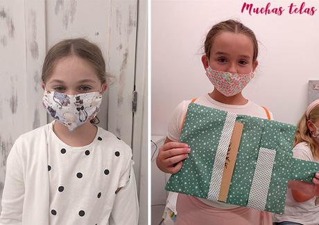 Niñas mostrando mascarila y carpeta