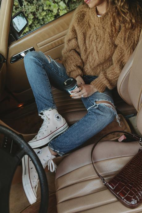 Sara is wearing Isabel Marant camel knit sweater, Moussy Vintage tapered jeans, By Far leather bag and All-Star retro sneakers