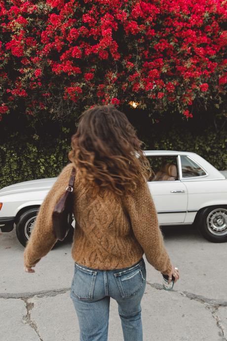 Sara is wearing Isabel Marant camel knit sweater, Moussy Vintage tapered jeans, By Far leather bag and All-Star retro sneakers