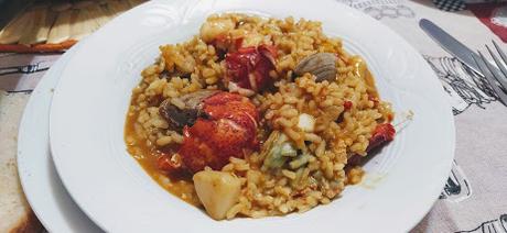 Plato con arroz caldoso de bogavante, sepia y almejas