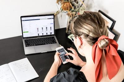 Mujer con pañuelo y horquillas en el cabello delante de un ordenador y un smartphone