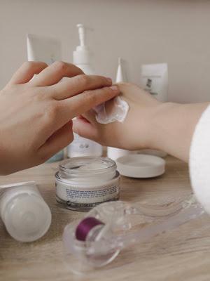 Mujer aplicándose crema en las manos Mujer aplicándose crema en las manos