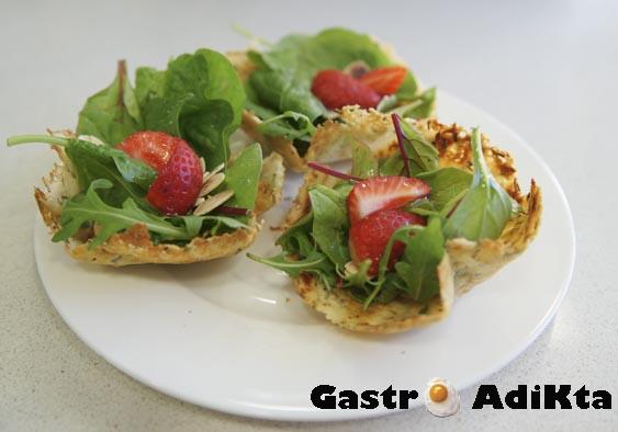 Aperitivos crujientes de parmesano y romero con ensalada de espinacas y fresas