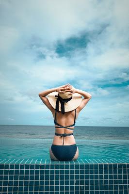 Mujer tomando el sol con un bañador con la espalda cruzada