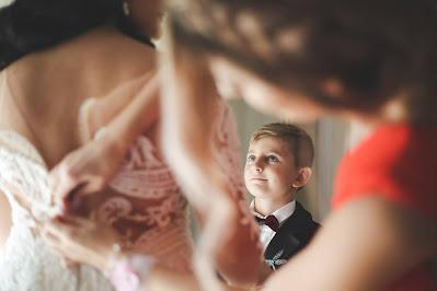 Niño mirando a la novia mientras le terminan de abrochar el vestido