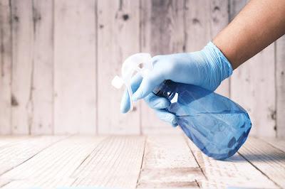 Persona sosteniendo un espray con la mano enguantada