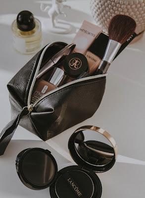 Bolsa con productos de maquillaje y una brocha Bolsa con productos de maquillaje y una brocha