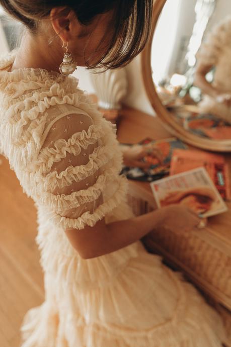 Sara from Collage Vintage is wearing a Needle and Thread ruffle gown in ivory color