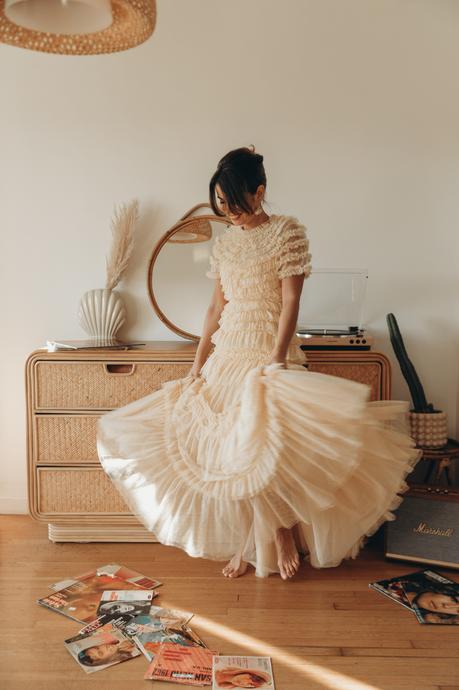 Sara from Collage Vintage is wearing a Needle and Thread ruffle gown in ivory color