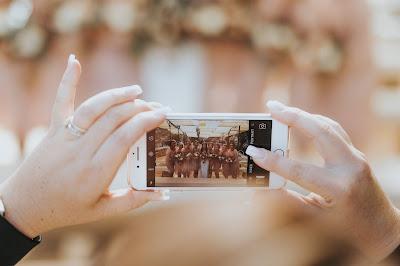 Invitada tomando una foto a la novia y a las damas de honor con su móvil Invitada tomando una foto a la novia y a las damas de honor con su móvil