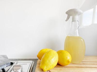 Limones y espray con jugo de limón exprimido