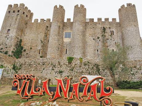 El letrero de Vila Natal Ăbidos junto al castillo de Ăbidos, Portugal.