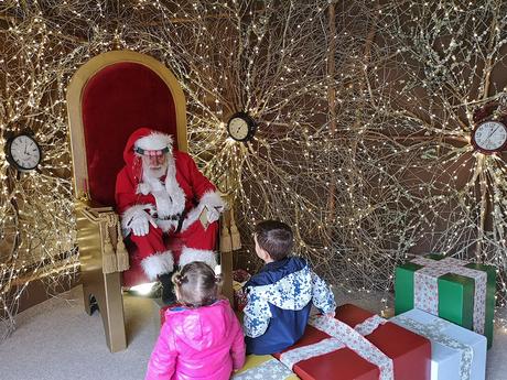 Dos niĂąos con PapĂĄ Noel en Vila Natal. Ăbidos
