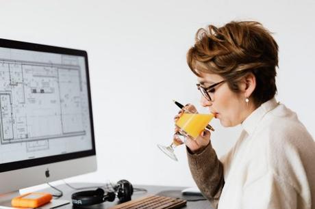 female architect drinking juice while working on new project