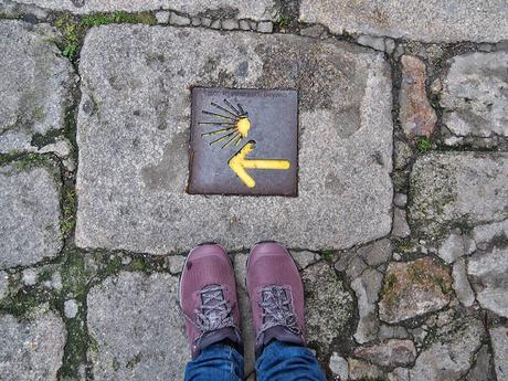 pies junto a una señal del camino de Santiago en el suelo de Oporto