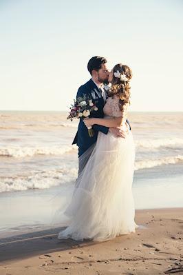 Pareja besándose en una playa con viento