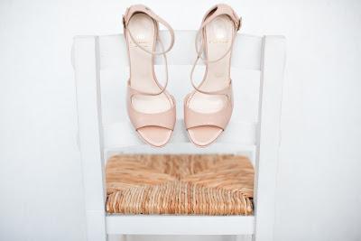 Sandalias de novia rosas colgadas de una silla