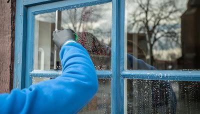 Persona limpiando el exterior de las ventanas