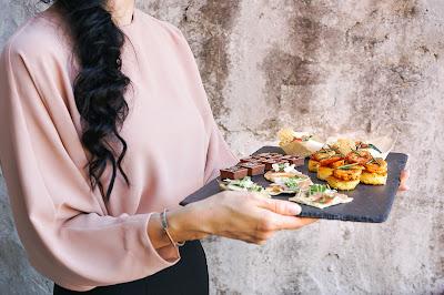 Camarera con una bandeja de canapés en la mano