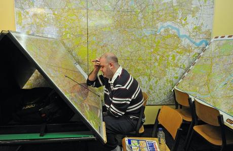 Man studying massive maps of London