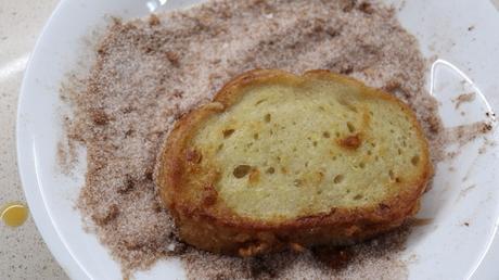 Rebozar las torrijas con azúcar y canelas