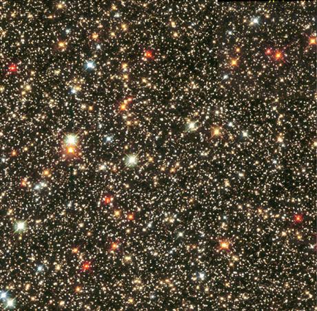 Imagen del telescopio espacial Hubble de la nube estelar de Sagitario.  La imagen muestra muchas estrellas de varios colores, blancas, azules, rojas y amarillas repartidas sobre un fondo negro.  Los colores de estrella más comunes en esta imagen son el rojo y el amarillo.