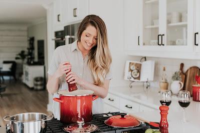 Mujer cocinando y añadiendo pimienta a una olla