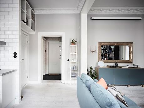 delikatissen tiny scandi apartment sofá rinconera sofa azul scandi sofa salón cocina abierto Piso nórdico pequeño estilo nórdico distribución diáfana decoración de interiores blue couh  