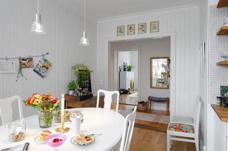 Un piso para vivir y disfrutar sofá de cuero blanco paredes paneladas con madera papel de pared de árboles muebles viejos pintados en blanco muebles antiguos reciclados kitchen aid estilo nórdico estanterias en la cocina encimera de madera diseño de interiores decoración de interiores decoración acogedora cocina blanca cocina abierta casas para vivir casas de revista casas acogedoras banco junto a la ventana banco baúl