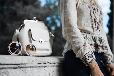 Mujer con un bolso y unas gafas al lado