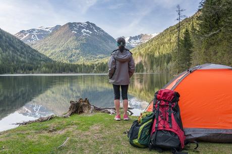 Una lista de accesorios para acampar que necesitará en su viaje de campamento Una persona parada frente a una montaña Descripción generada automáticamente