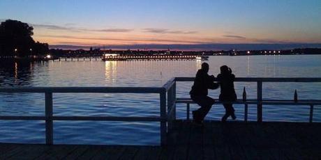 Pareja en el puerto de Kiel, mirando la puesta de sol