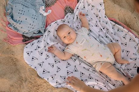 5 prendas de ropa imprescindibles para vestir a bebés y niños en verano bebe con pelele en la playa