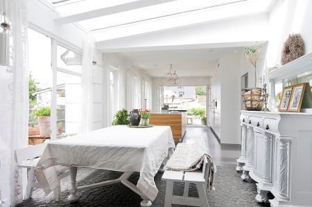 villa en suecia tragaluz en el comedor sofá en el baño piel de cordero en decoración muebles de terraza muebles de ikea muebles blancos grandes ventanales estilo nórdico estilo escandinavo diseño nórdico diseño de terrazas diseño de interiores decoración sueca decoración en blanco decoración de interiores cocinas con isla cocinas con armarios altos cocina moderna cocina blanca claraboya en una casa baño con piedra caliza 