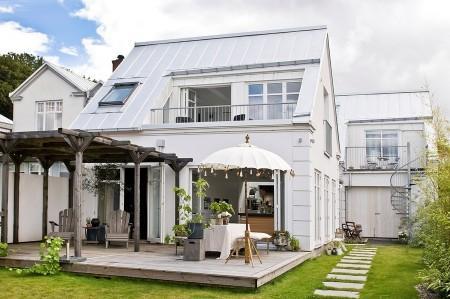 villa en suecia tragaluz en el comedor sofá en el baño piel de cordero en decoración muebles de terraza muebles de ikea muebles blancos grandes ventanales estilo nórdico estilo escandinavo diseño nórdico diseño de terrazas diseño de interiores decoración sueca decoración en blanco decoración de interiores cocinas con isla cocinas con armarios altos cocina moderna cocina blanca claraboya en una casa baño con piedra caliza 