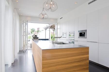 villa en suecia tragaluz en el comedor sofá en el baño piel de cordero en decoración muebles de terraza muebles de ikea muebles blancos grandes ventanales estilo nórdico estilo escandinavo diseño nórdico diseño de terrazas diseño de interiores decoración sueca decoración en blanco decoración de interiores cocinas con isla cocinas con armarios altos cocina moderna cocina blanca claraboya en una casa baño con piedra caliza 