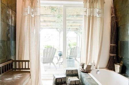 villa en suecia tragaluz en el comedor sofá en el baño piel de cordero en decoración muebles de terraza muebles de ikea muebles blancos grandes ventanales estilo nórdico estilo escandinavo diseño nórdico diseño de terrazas diseño de interiores decoración sueca decoración en blanco decoración de interiores cocinas con isla cocinas con armarios altos cocina moderna cocina blanca claraboya en una casa baño con piedra caliza 