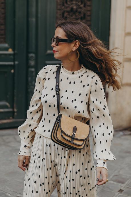 Polka dots set Sara from Collage Vintage at Saint Germain Paris wearing a Sézane polka dots set and a leather crossbody bag.